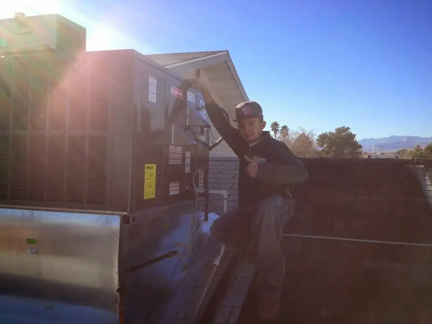 HVAC technician performing Air Duct Repair on a rooftop unit in Montclair